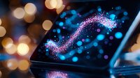 Magical glowing sparkles and bokeh lights on digital tablet screen creating ethereal atmosphere with blue and pink colors against dark background.