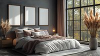 Modern bedroom interior with large windows, unmade bed, pampas grass decoration and three blank frames on dark gray wall, natural morning light.