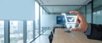 Businessman holding glowing shopping cart icon in modern office with city view, representing digital commerce, online retail, and e-commerce technology solutions.
