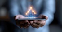 Glowing digital house hologram floating above smartphone in hands, representing smart home technology and real estate innovation in modern living space.