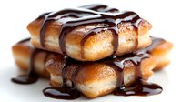 Freshly baked golden donuts drizzled with rich chocolate sauce isolated on white background for bakery menu design and culinary advertising projects.