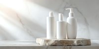 White cosmetic bottles on stone podium against marble background with sunlight and shadows, minimal luxury skincare product presentation for beauty brands.