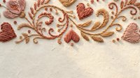 Elegant embroidered floral border with hearts and swirls in warm brown tones on cream fabric background for romantic textile design projects.