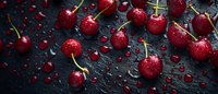 Fresh ripe cherries with water drops scattered on dark background, raw organic fruit with stems in dramatic lighting, panoramic food composition.