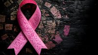 Pink awareness ribbon with textured pattern against dark grunge background, symbolic of breast cancer support and medical advocacy campaigns.