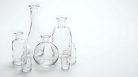 Clear glass laboratory bottles and flasks of various shapes and sizes arranged on white background for scientific research and chemistry experiments.