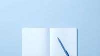 Young professional woman with medium skin tone writing in open notebook with blue pen on light blue background, suitable for business, education, planning, and productivity concepts.