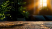 Rustic wooden table surface with natural wood grain texture in warm sunlight, green plants in blurred background creating cozy atmosphere.