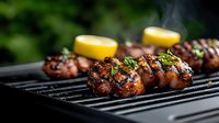 Juicy grilled chicken thighs with fresh herbs and lemon garnish cooking on barbecue grill grates with rising smoke and bokeh background. Perfect for summer recipes.