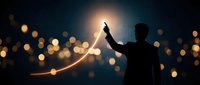 Young businessman silhouette pointing upward with glowing arrow chart against bokeh lights background showing growth success and achievement concept.