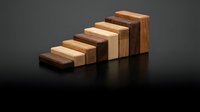 Wooden blocks arranged in ascending staircase pattern, showcasing natural wood grain and color variation from dark to light tones on reflective surface.