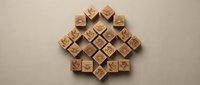 Wooden alphabet blocks arranged in diamond pattern on neutral background for educational toys and learning materials design projects.