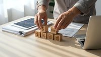 Business professional calculating tax percentage with wooden blocks on desk, financial planning and accounting concept for corporate taxation services.
