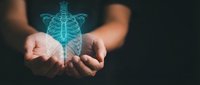 Holographic human skeleton floating above open hands on dark background. Medical education, healthcare technology and anatomical study concept for presentations.