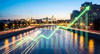 Urban cityscape with digital financial data overlay showing rising stock market graphs and trading analytics at twilight with illuminated buildings and water reflections.