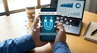 Business professional holding smartphone with digital marketing interface displaying customer retention and analytics icons over modern office workspace.
