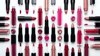 Colorful cosmetic makeup collection with lipsticks, lip glosses and beauty products arranged on white background for fashion and style concepts.