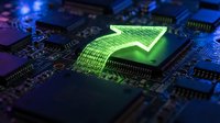 Green security shield with binary code on computer motherboard circuit board representing cybersecurity protection and data encryption technology.