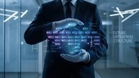 Professional businessman in dark suit holding glowing digital holographic interface with data visualization in modern corporate office environment.