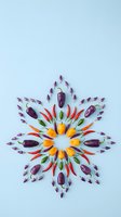 Colorful mandala pattern made from fresh vegetables and peppers arranged in symmetrical design on light blue background for healthy eating concepts.