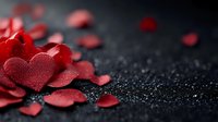 Red heart-shaped confetti scattered on dark textured surface with water droplets, romantic Valentine's Day celebration decoration for love themes.