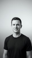 Middle-aged Caucasian male wearing black t-shirt against neutral gray background. Professional headshot suitable for corporate profiles, business websites, and personnel directories.