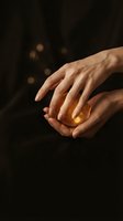 Cupped hands holding warm golden light against dark background with bokeh effects for spiritual and hope concepts.