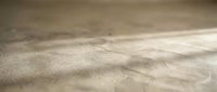 Close-up of sandy beach surface with natural wind patterns and texture details creating organic desert-like landscape for nature backgrounds.