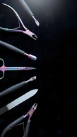 Professional manicure and pedicure tools with iridescent rainbow finish arranged on dark background, nail care salon set with copy space.