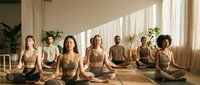 Diverse group of women practicing meditation in lotus pose during yoga class in bright studio with natural sunlight and plants.