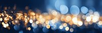 Festive bokeh lights creating magical blur effect in blue and gold colors, panoramic background for holiday season designs and celebrations.