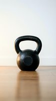 Black kettlebell weight on wooden floor against white wall background, isolated for fitness, gym training, strength exercise, and workout design use.