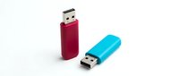 Two USB flash drives in red and turquoise isolated on white background, ready for design use in technology and data storage concepts.