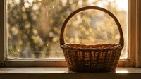 Empty wicker basket on wooden windowsill with warm sunlight streaming through glass creating magical bokeh effect for home decor and lifestyle concepts.