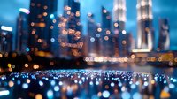 Blurred city lights and skyscrapers reflected in water at night create dreamy urban landscape with bokeh effect in blue and orange tones, modern cityscape background.
