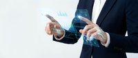 Professional businessman in dark suit analyzing holographic financial data charts and graphs with futuristic digital interface technology for business analytics.