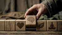 Mental health awareness concept with wooden blocks featuring brain, heart, leaf and meditation symbols representing holistic wellness and emotional balance.