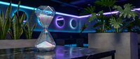 Futuristic hourglass with glowing sand on reflective surface in modern neon-lit interior with purple and blue lighting creating sci-fi atmosphere for technology concepts.