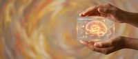 Hands protecting glowing brain hologram with neural networks on golden energy background representing mental health and cognitive protection.