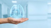 Human hand holding glowing transparent lungs hologram in modern medical facility for healthcare technology and respiratory system concepts.