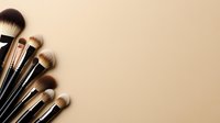 Professional makeup brushes arranged in fan shape against neutral beige background, creating minimal composition for beauty and cosmetic industry content.