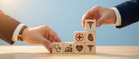 Healthcare professional and businessman stacking wooden blocks with medical icons including stethoscope, heart, and graph symbols against blue sky background for insurance and wellness concept.