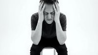 Young woman experiencing severe headache holding head in hands showing pain and stress on white background.