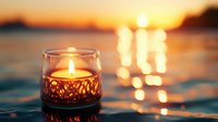 Glowing candle in decorative glass holder floating on calm water during golden sunset with warm reflections creating peaceful ambiance for relaxation and meditation.