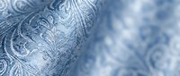 Closeup of blue and white ornamental fabric with intricate paisley and floral patterns, suitable for textile design, fashion, and home decor projects.