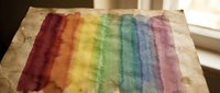 Watercolor rainbow stripes on textured paper with natural lighting, artistic paint technique for creative projects and design applications.