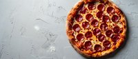 Hot pepperoni pizza with melted mozzarella cheese and tomato sauce on rustic gray concrete background, top view with copy space for menu design.