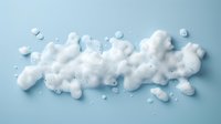 White soap foam bubbles scattered on light blue background, creating abstract shapes and textures with soft shadows for cosmetic and hygiene product advertising.
