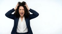 Frustrated businesswoman screaming with hands in hair showing stress and overwhelm isolated on white background for workplace mental health concepts.