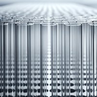 Rows of empty glass test tubes arranged in laboratory setting for scientific research and medical testing applications.